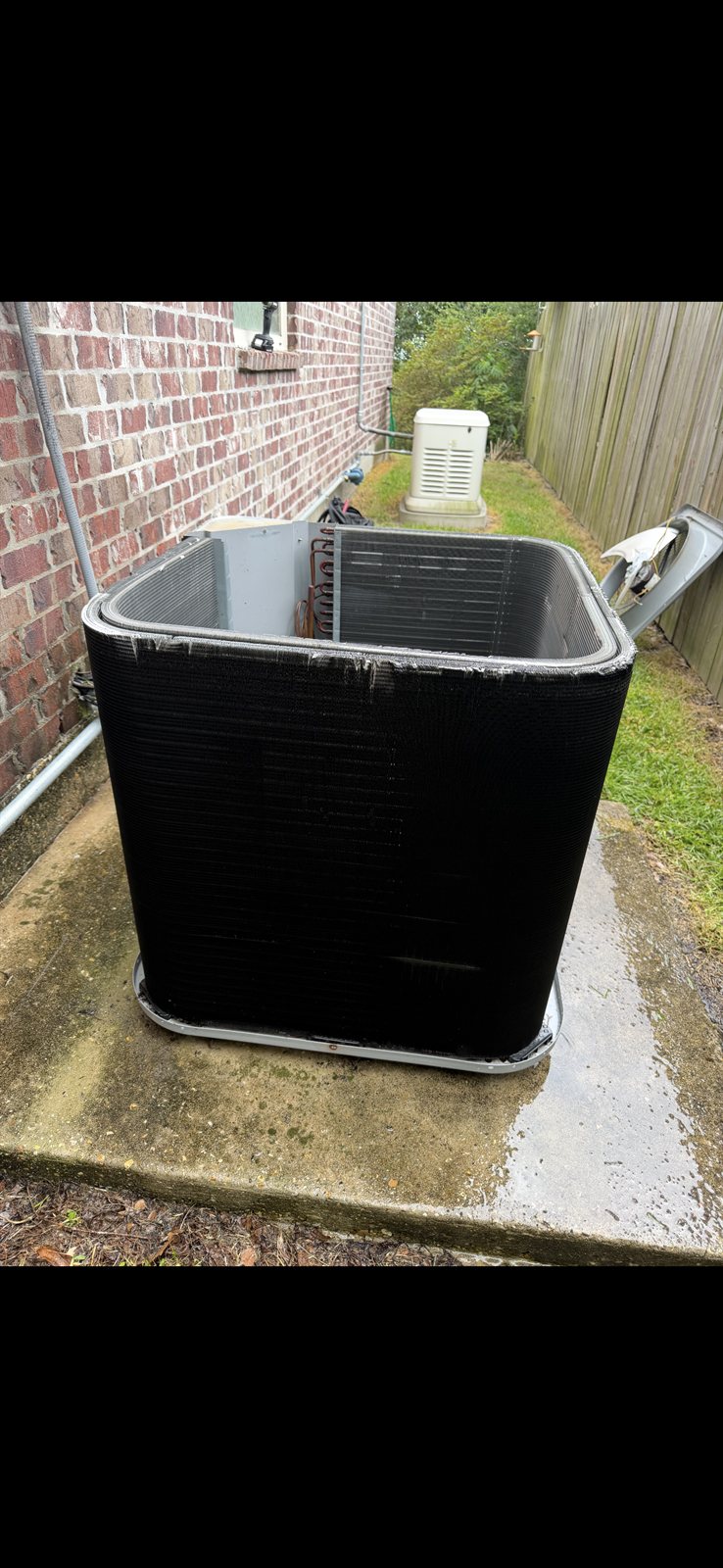 A/C condenser coil being cleaned during a seasonal tune-up